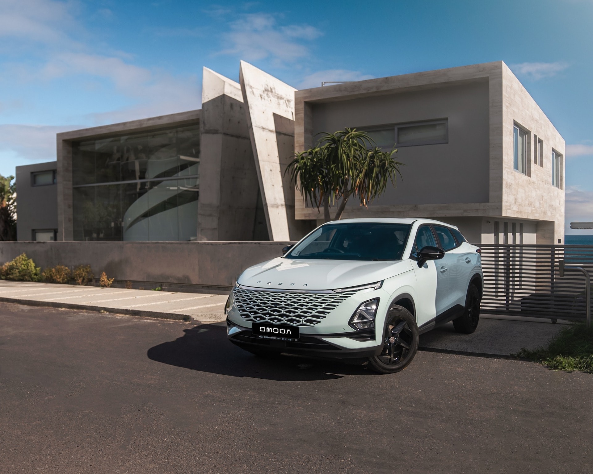 El Omoda 5 aparcado frente a una arquitectura moderna, enfoque en la fachada delantera.