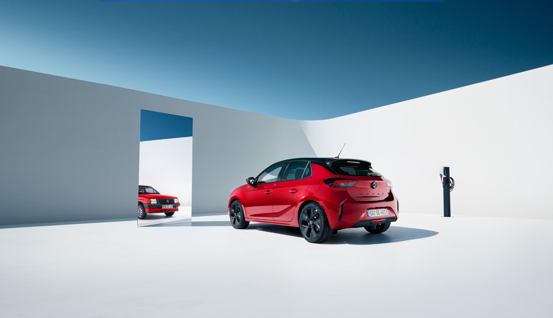 Opel Astra híbrido rojo, mostrando su diseño trasero junto a un punto de carga.