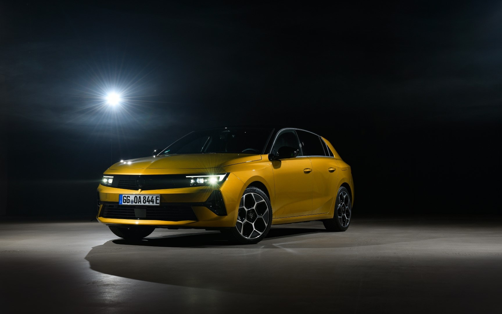 Imagen frontal del Opel Astra híbrido iluminando su camino en la noche.