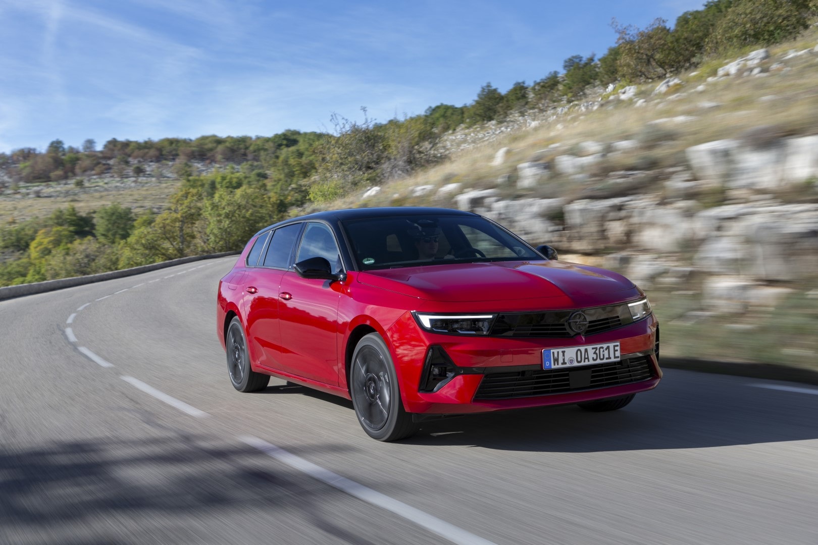 Vista frontal lateral del Opel Astra Sports Tourer en una carretera de montaña.