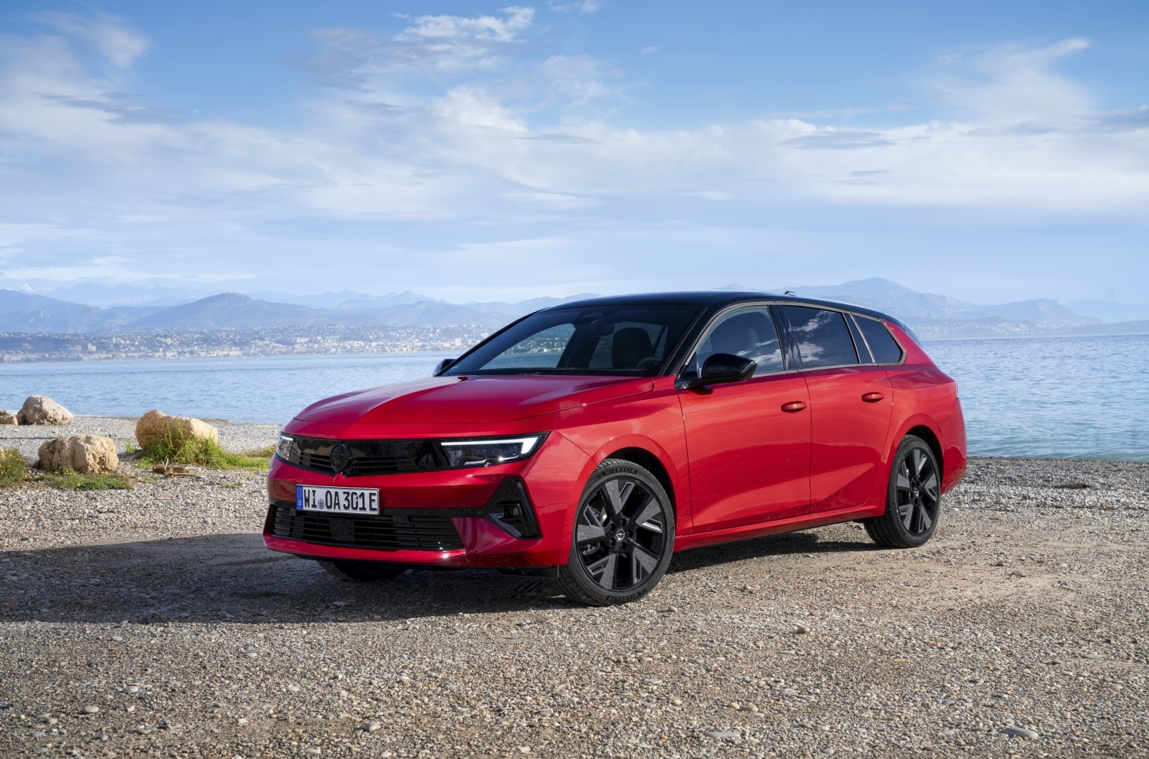 Vista angular frontal y lateral del Opel Astra Sports Tourer en contexto costero.