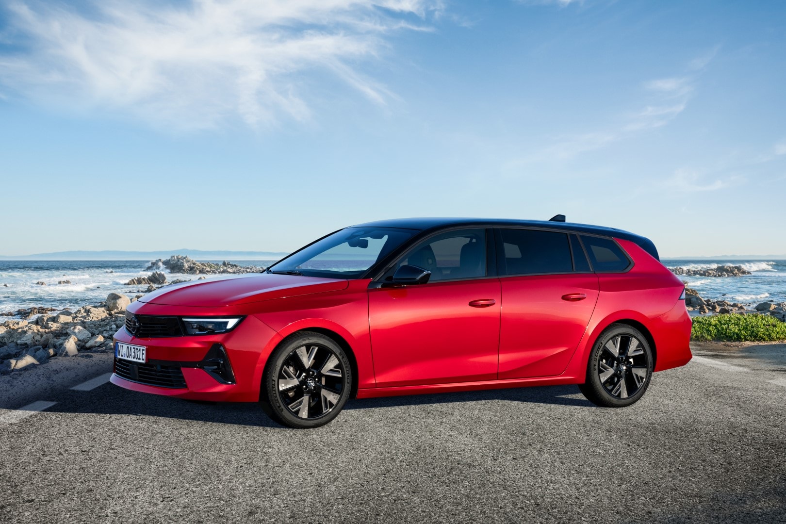 Visión completa lateral del Opel Astra Sports Tourer estacionado junto al mar.