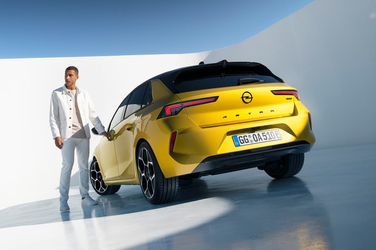 Vista trasera del Opel Astra junto a un conductor, resaltando el diseño de la zaga. Vista trasera del Opel Astra junto a un conductor, resaltando el diseño de la zaga.