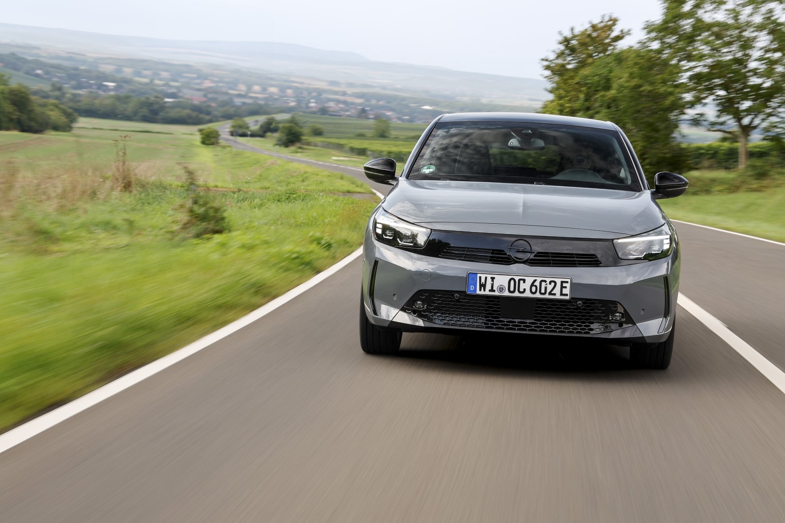 Vista frontal del Opel Corsa-e en movimiento, destacando su diseño dinámico.