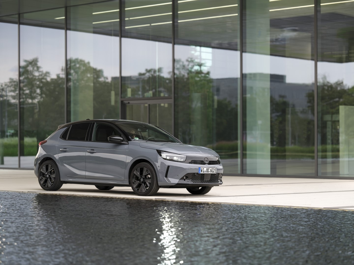 El Corsa-e eléctrico capturado con un diseño reflectante y moderno sobre el agua.