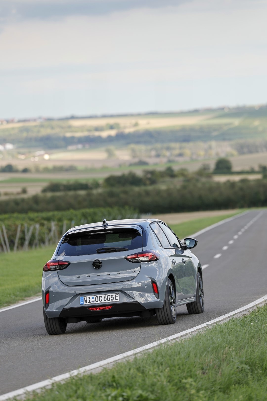 Visión trasera del Opel Corsa-e en carretera, realzando su diseño y líneas traseras.