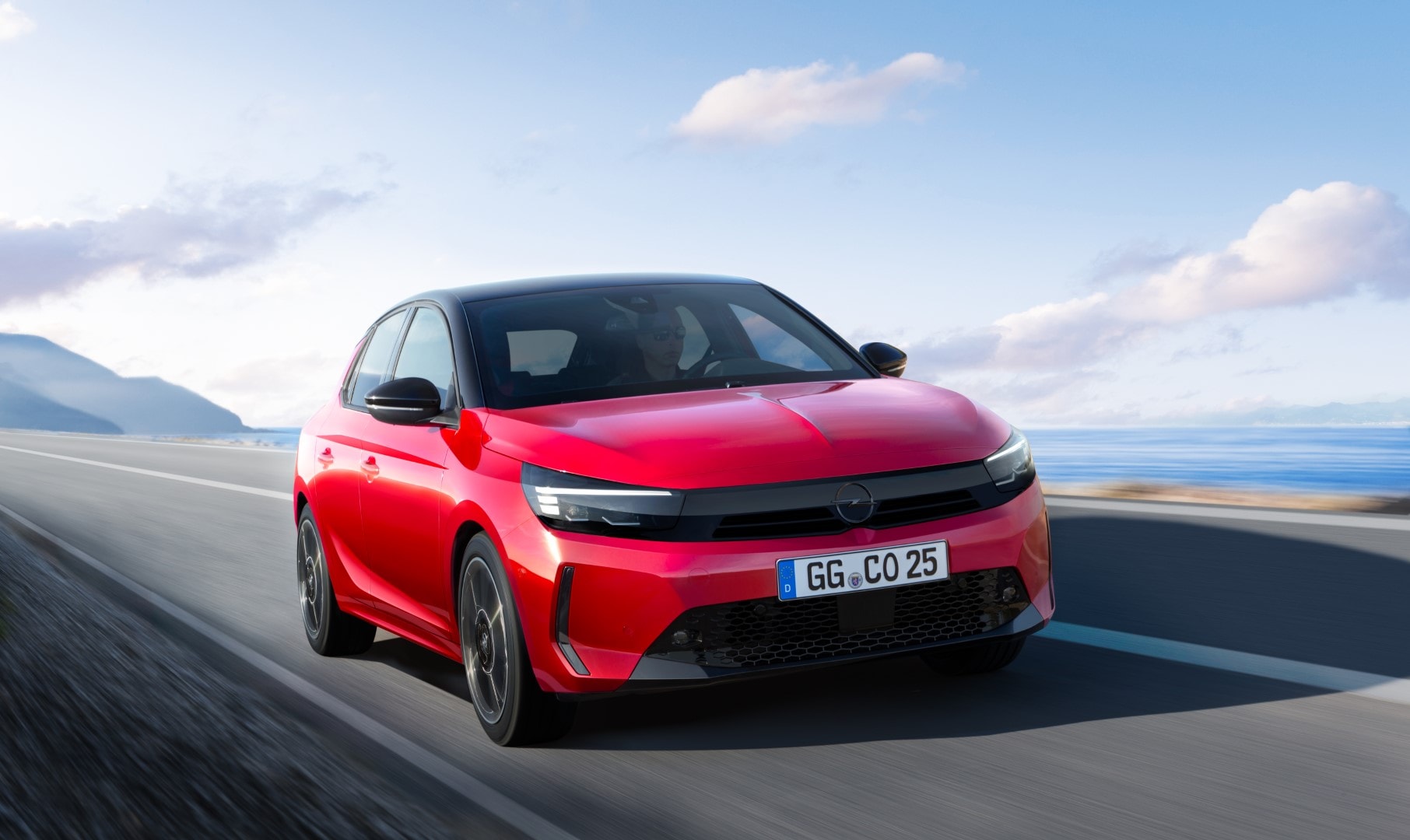 Imagen dinámica del Opel Corsa, destacando su frente y lado en carretera abierta.