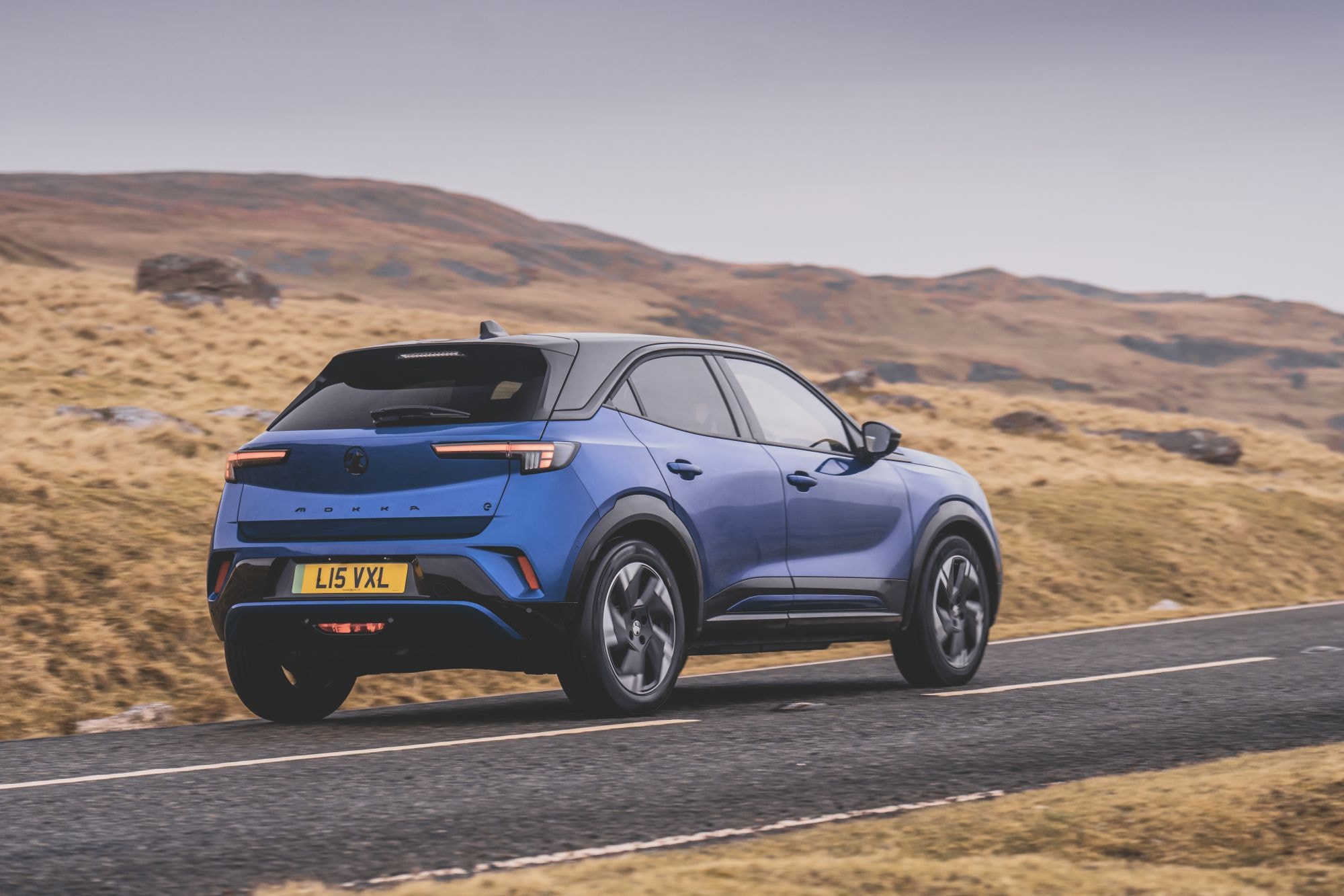 El Mokka-e en movimiento por carretera, destacándose con su estilo.