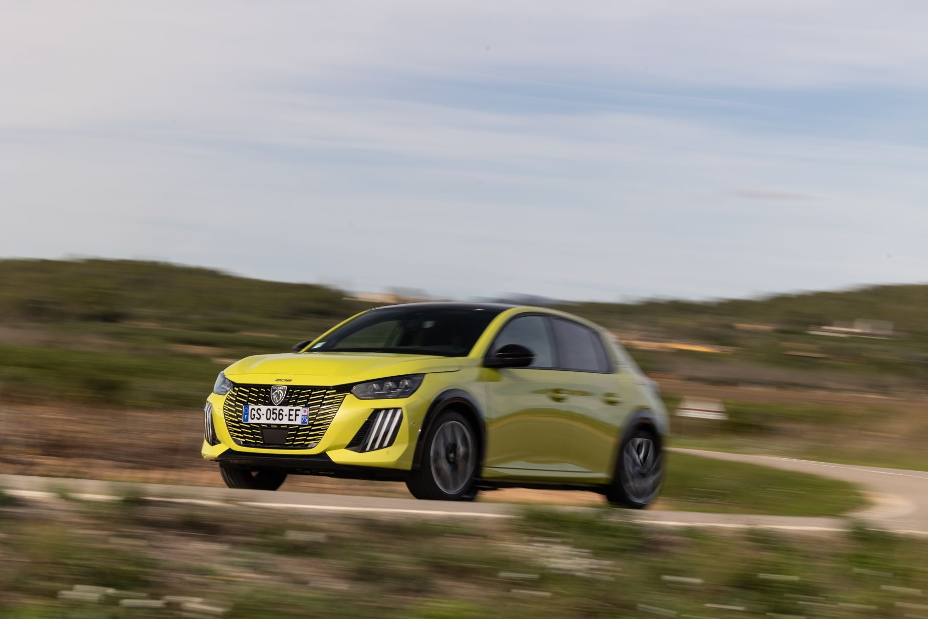 Perspectiva trasera del Peugeot 208 en un entorno rural.