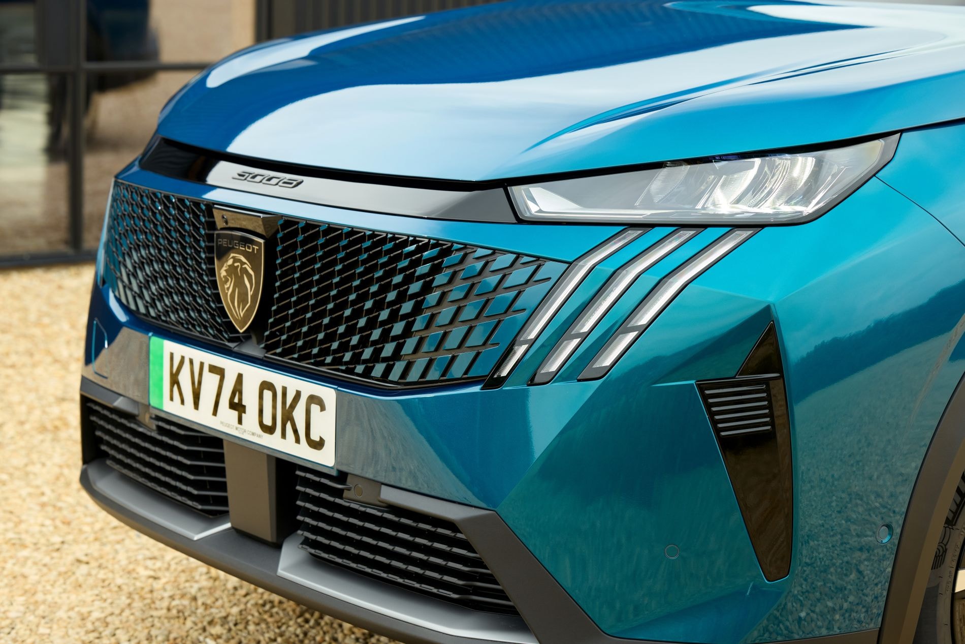 Peugeot 5008 eléctrico posando en un entorno moderno.