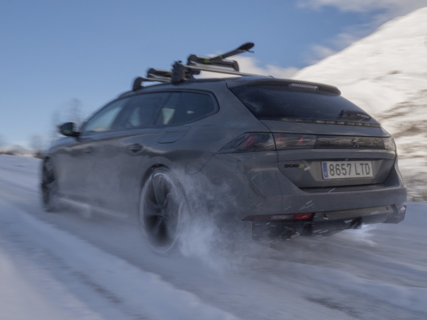 Peugeot 508 SW en acción sobre pista nevada, mostrando su capacidad en condiciones invernales.