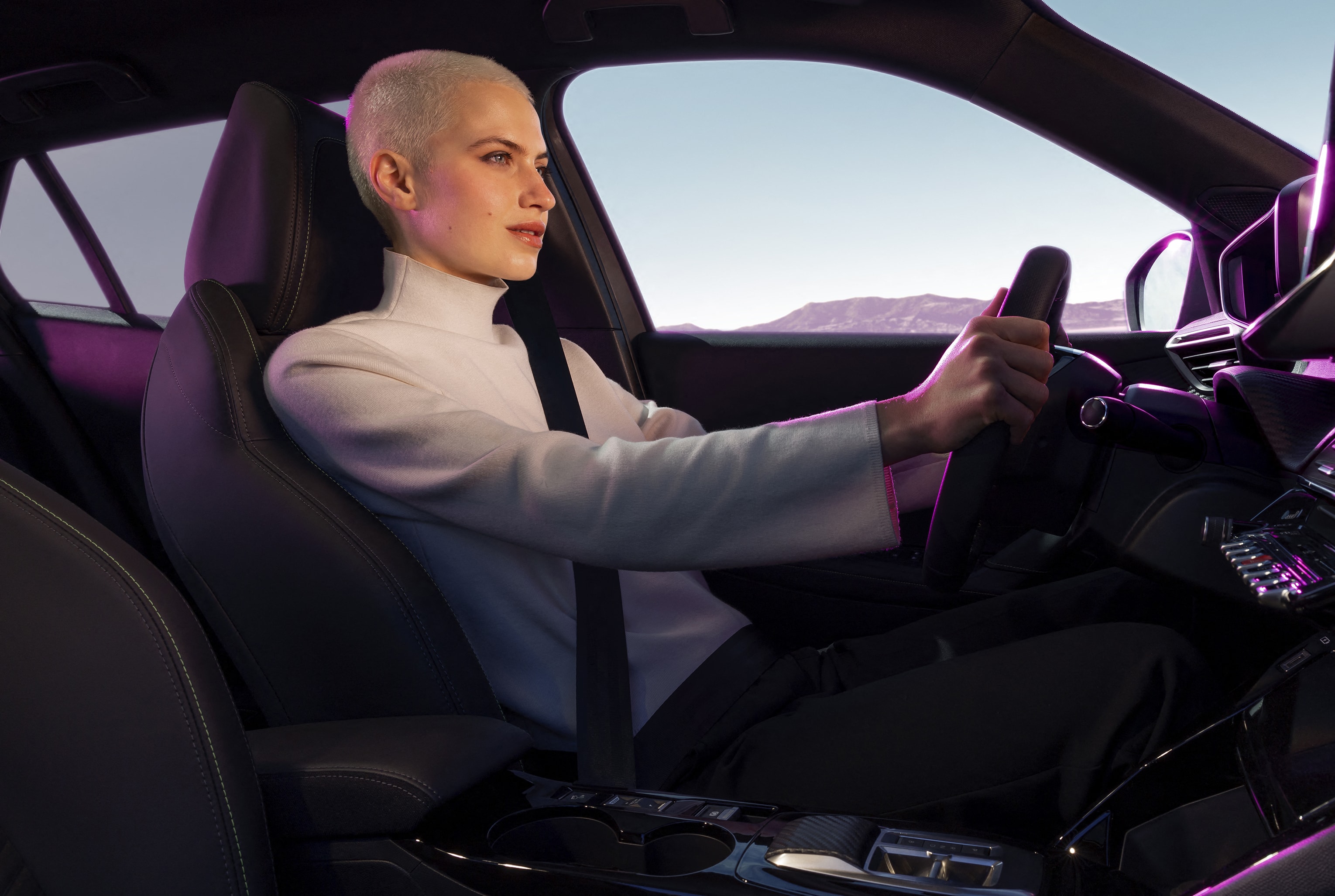 Persona al volante del Peugeot e-2008, destacando el interior y ergonomía.