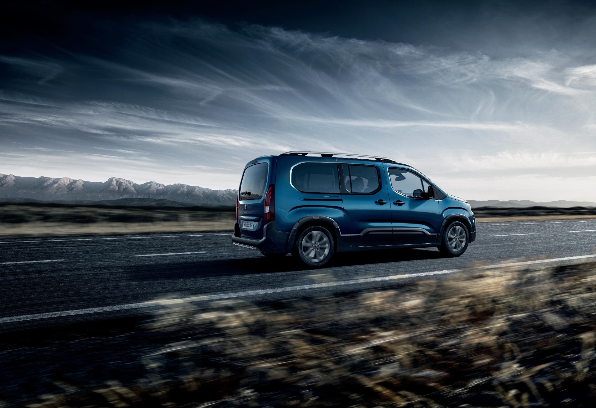 Perfil lateral del Peugeot e-Rifter en movimiento.