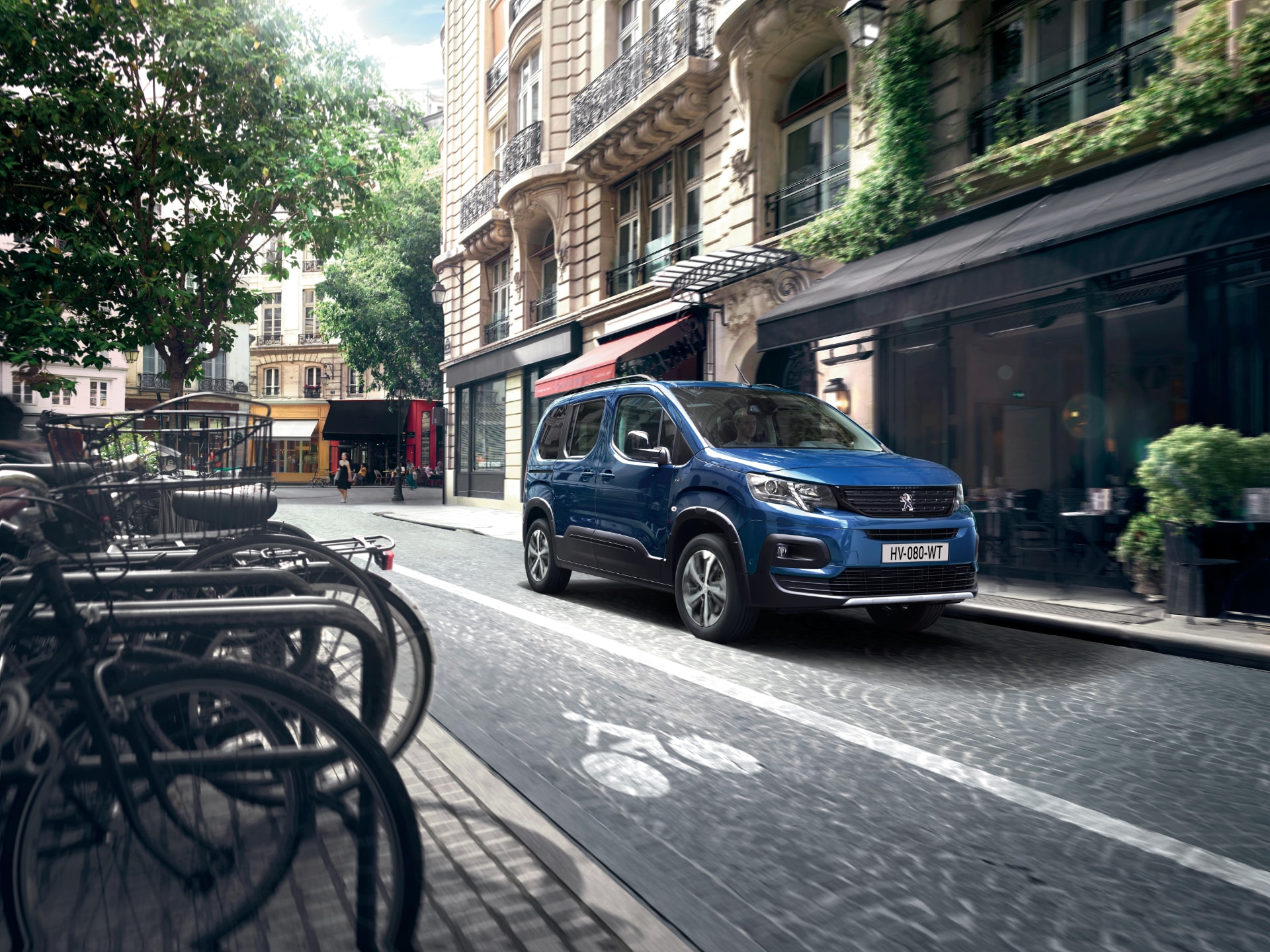 Vista dinámica del Peugeot e-Rifter en entorno urbano, destacando su frontal.