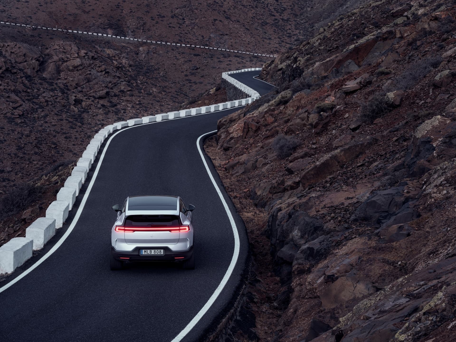 La trasera del Polestar 3 capturada en una toma dinámica durante un ascenso montañoso.
