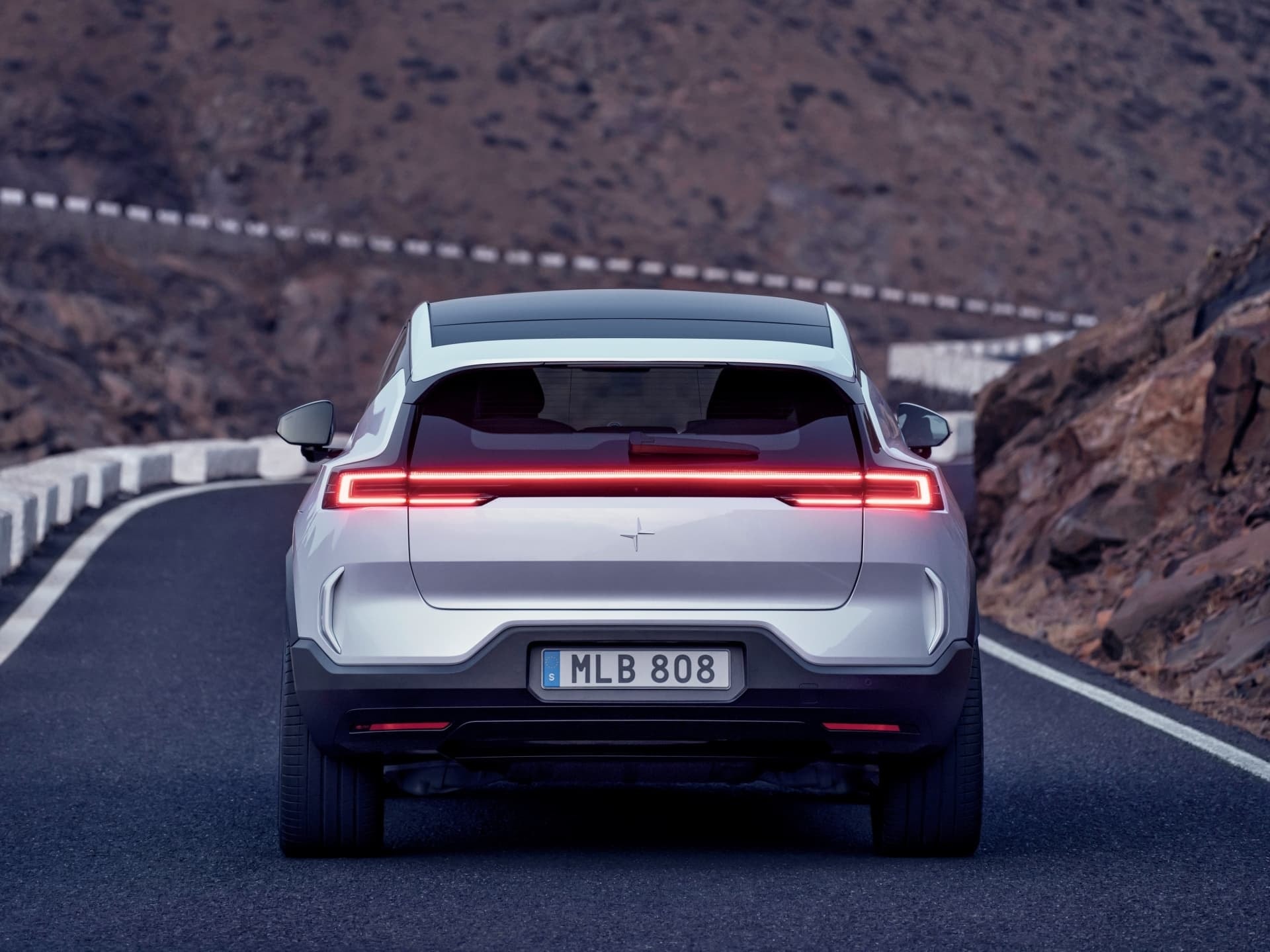 Vista trasera del Polestar 3, enmarcado por un escenario natural imponente.