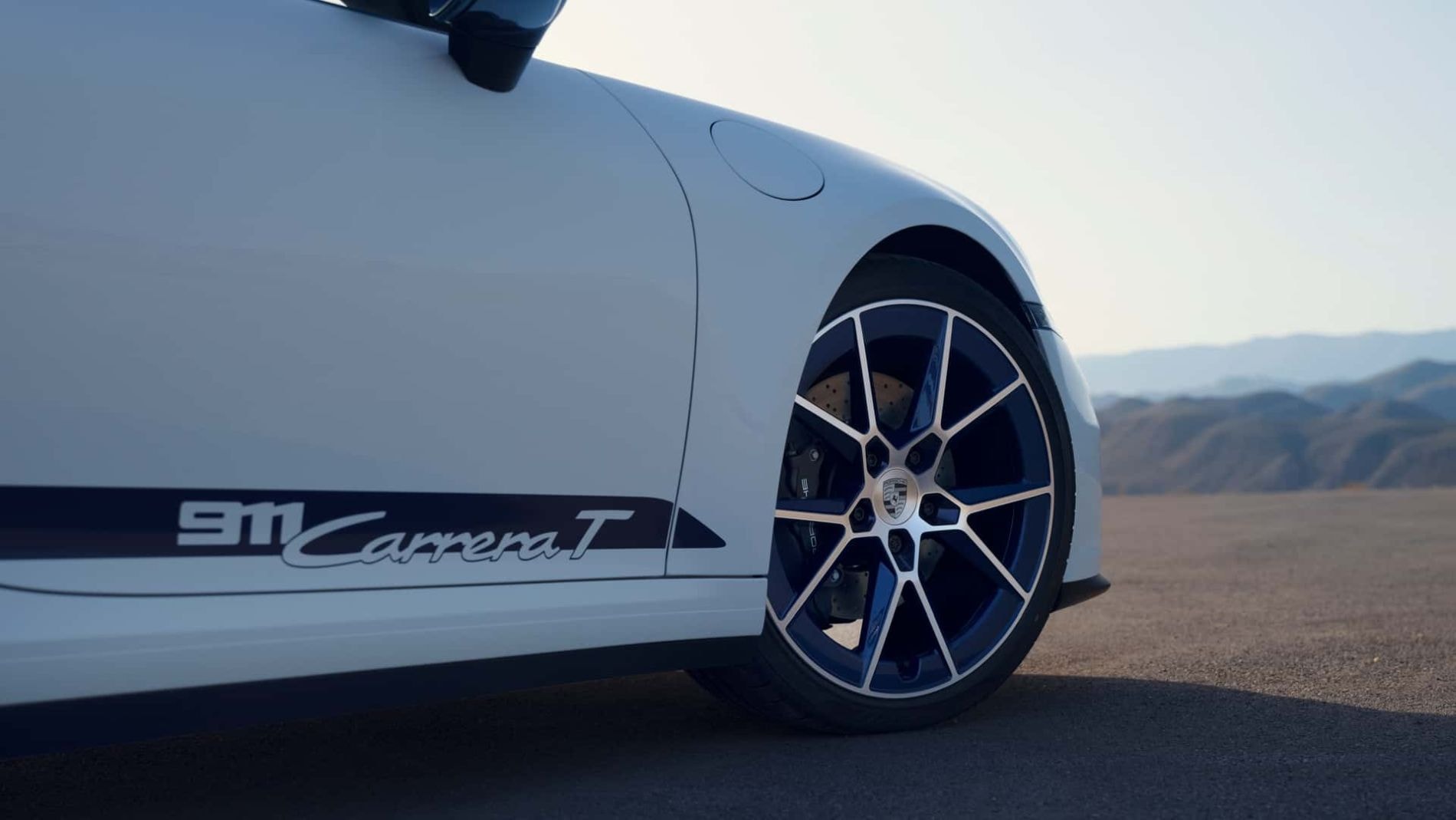 Vista lateral del Porsche 911 Carrera T, destacando su elegante diseño y llantas.