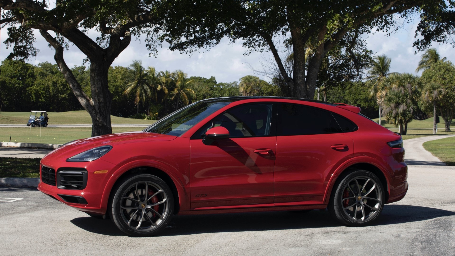 Porsche Cayenne Coupé en lateral, con campo de golf al fondo.