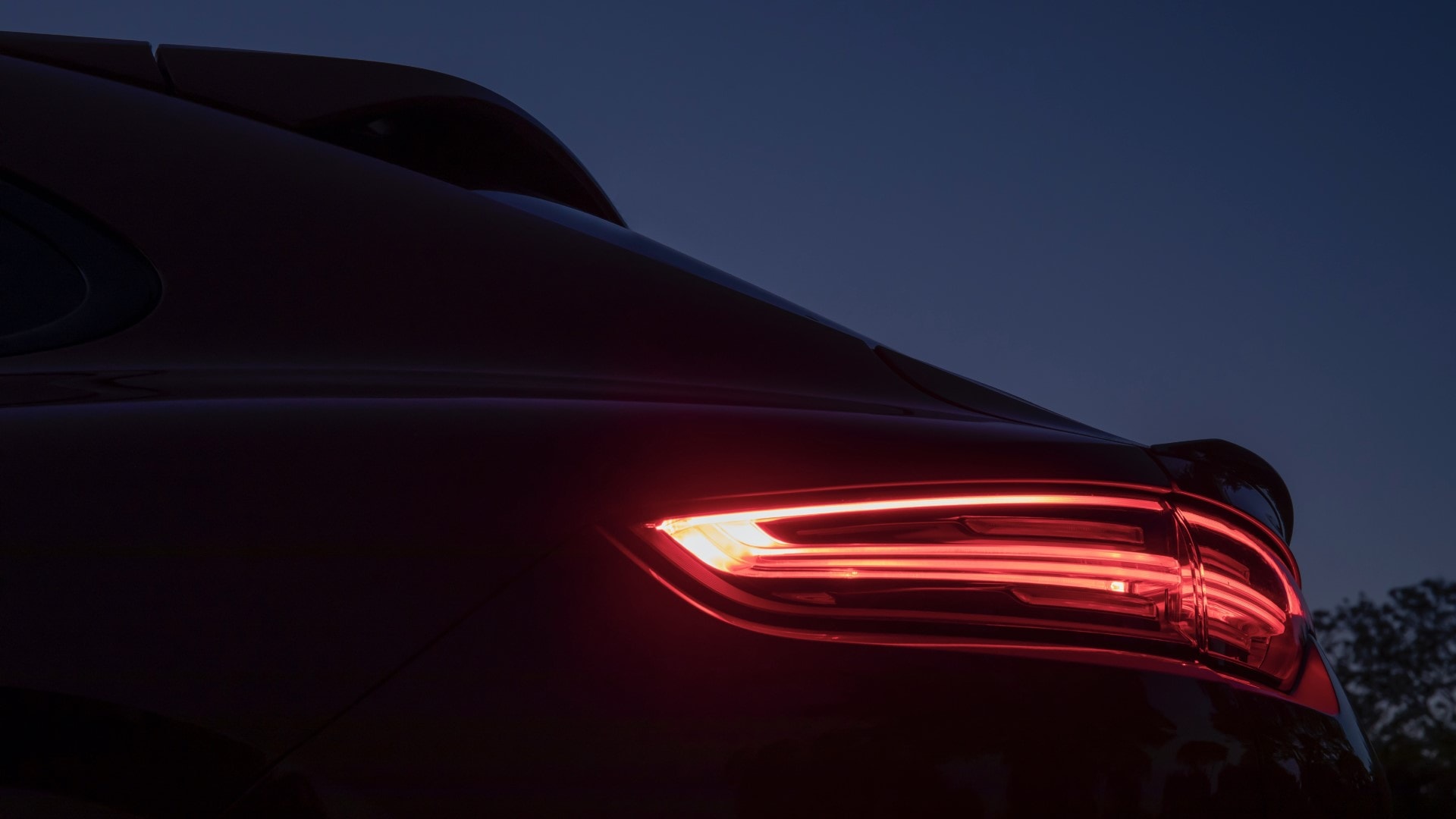 Perfil lateral del Porsche Cayenne Coupé en un atardecer, línea de techo descendente característica.