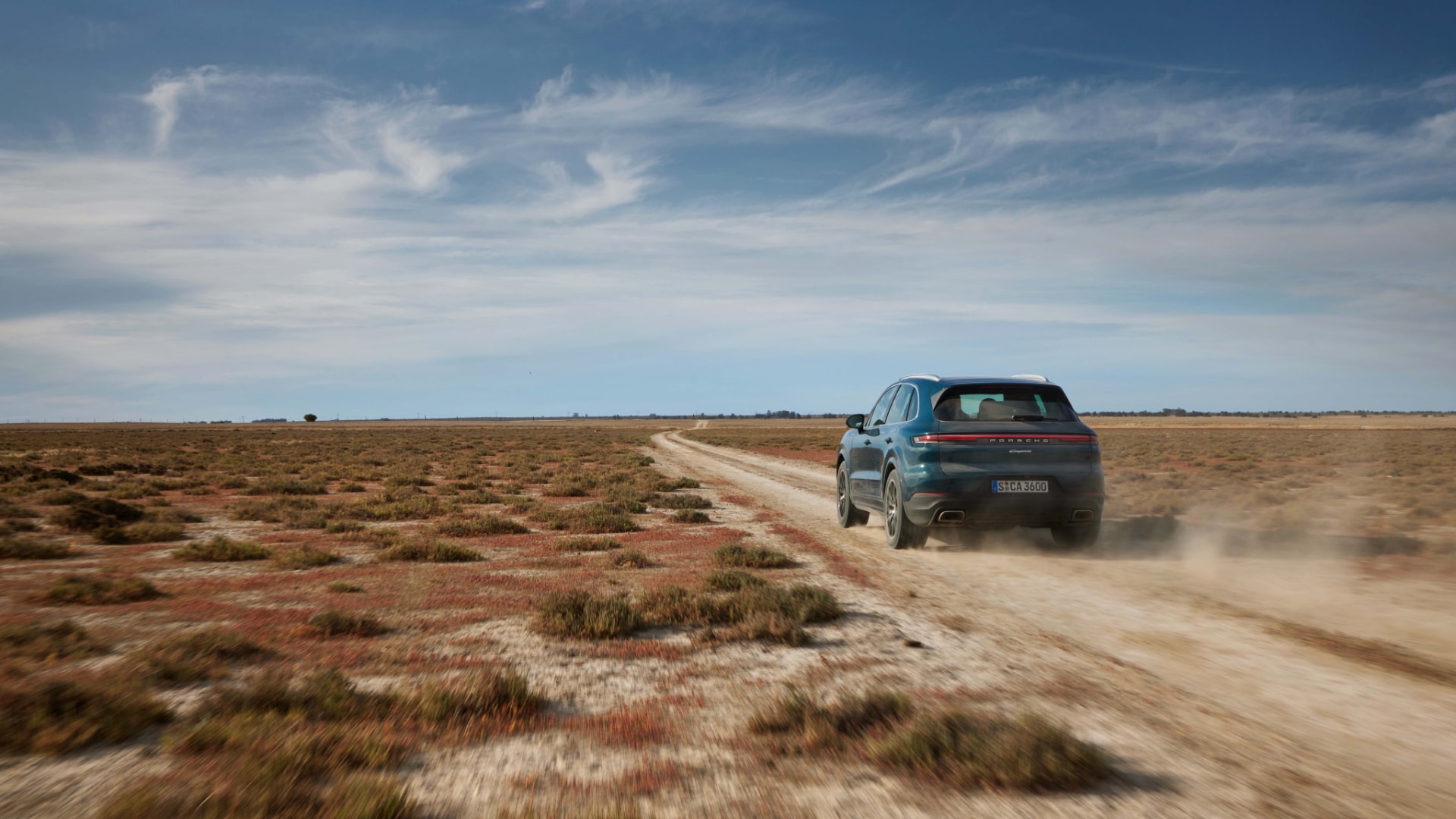 El Porsche Cayenne S Hybrid mostrando su capacidad todoterreno en un camino de tierra.