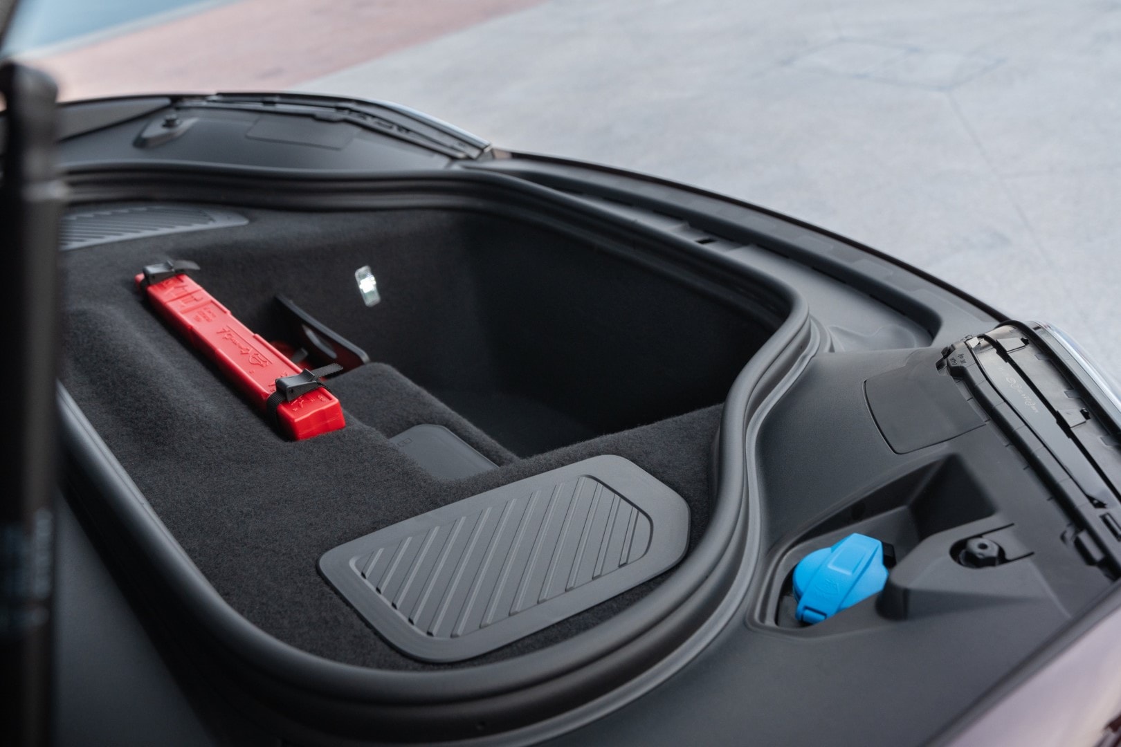 Espacio de almacenamiento en el maletero del Porsche Macan con kit de emergencia.