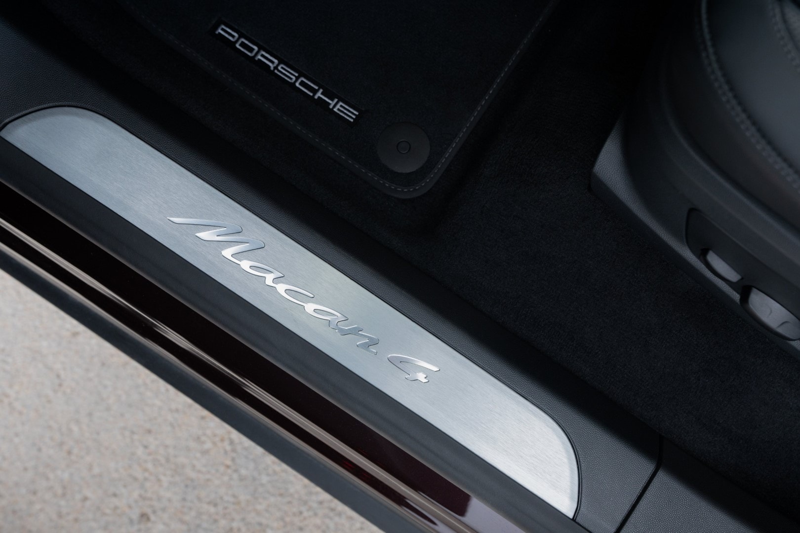 Umbral de la puerta del Porsche Macan con iluminación y la inscripción 'Macan 4'.