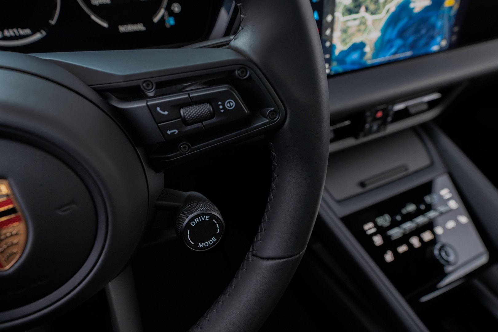 Primer plano de los comandos en el volante del Porsche Macan, demostrando la atención al detalle de la marca.