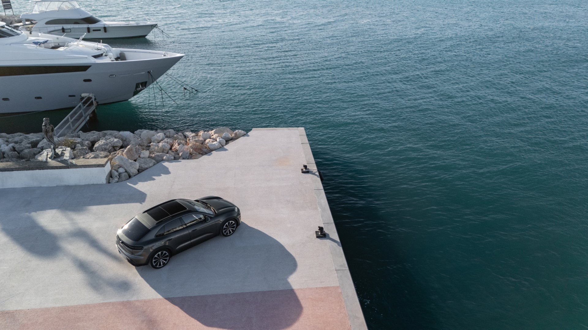 Perspectiva superior de un Porsche Macan en un muelle, resaltando su techo y diseño lateral.