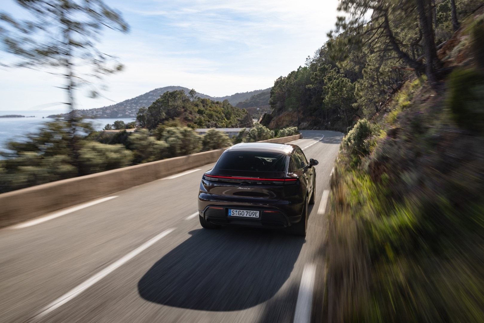 Porsche Macan en carretera, mostrando su línea trasera y la fluidez de su diseño.