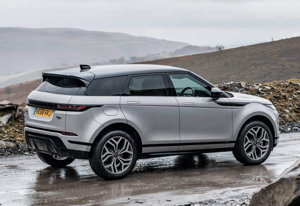 Vista posterior lateral del Evoque destacando su diseño robusto en terreno rocoso.