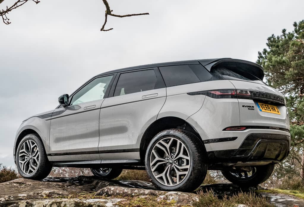 Perfil del Evoque híbrido en terreno natural; diseño moderno y robusto.