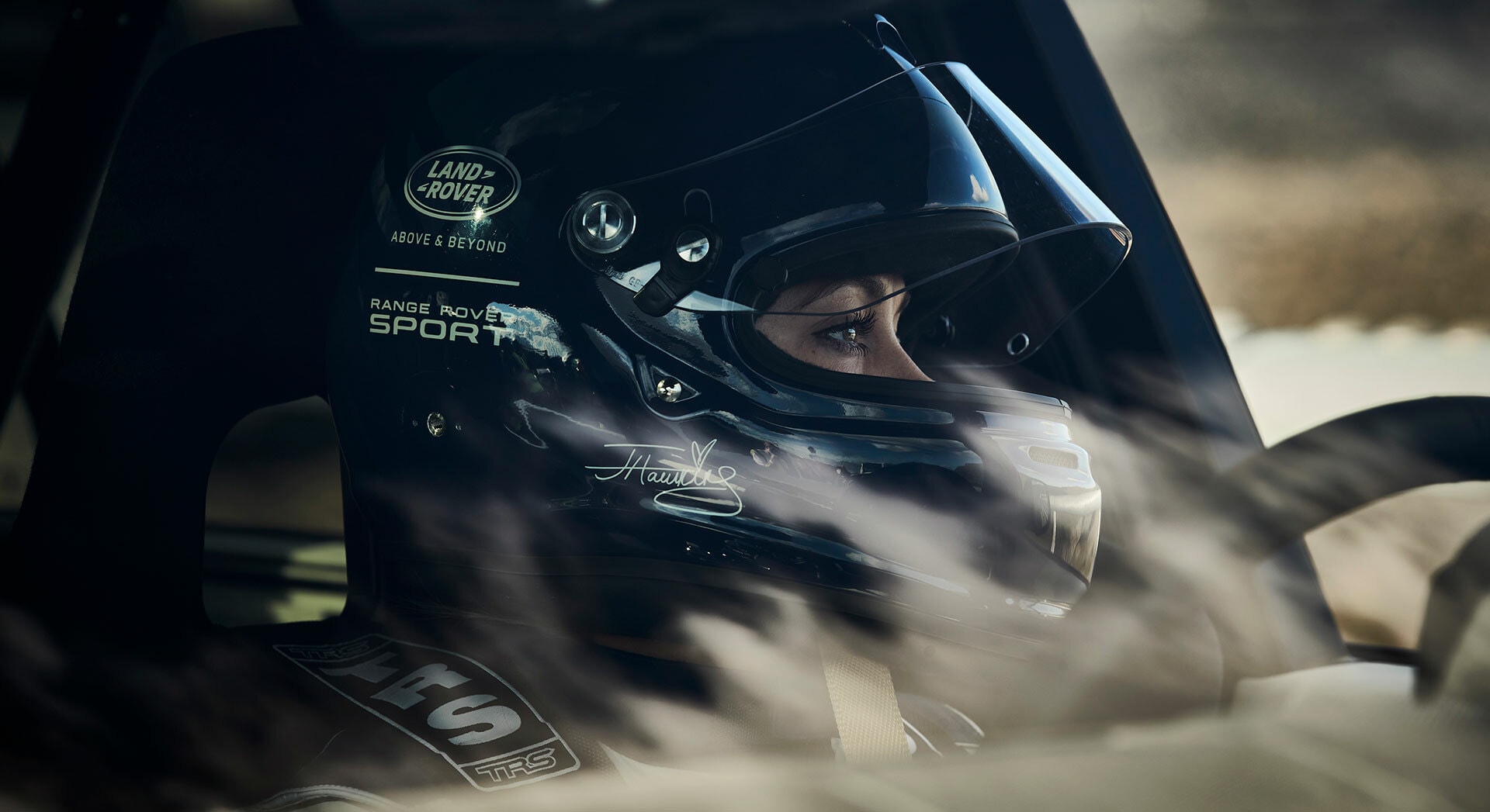 Piloto de carreras con casco en vehículo, concentración pura.