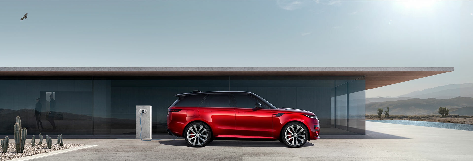 Esta toma lateral del Range Rover Sport en rojo permite apreciar la silueta fluida y elegante del vehículo.