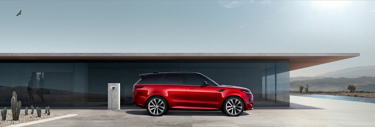 Esta toma lateral del Range Rover Sport en rojo permite apreciar la silueta fluida y elegante del vehículo. Esta toma lateral del Range Rover Sport en rojo permite apreciar la silueta fluida y elegante del vehículo.