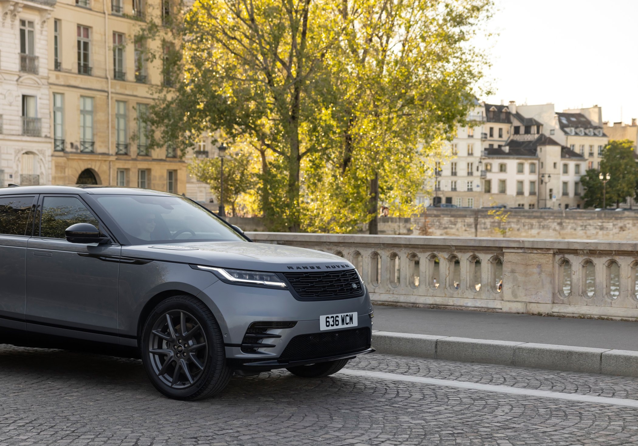 El Range Rover Velar avanzando por un camino arbolado, elegante y poderoso.