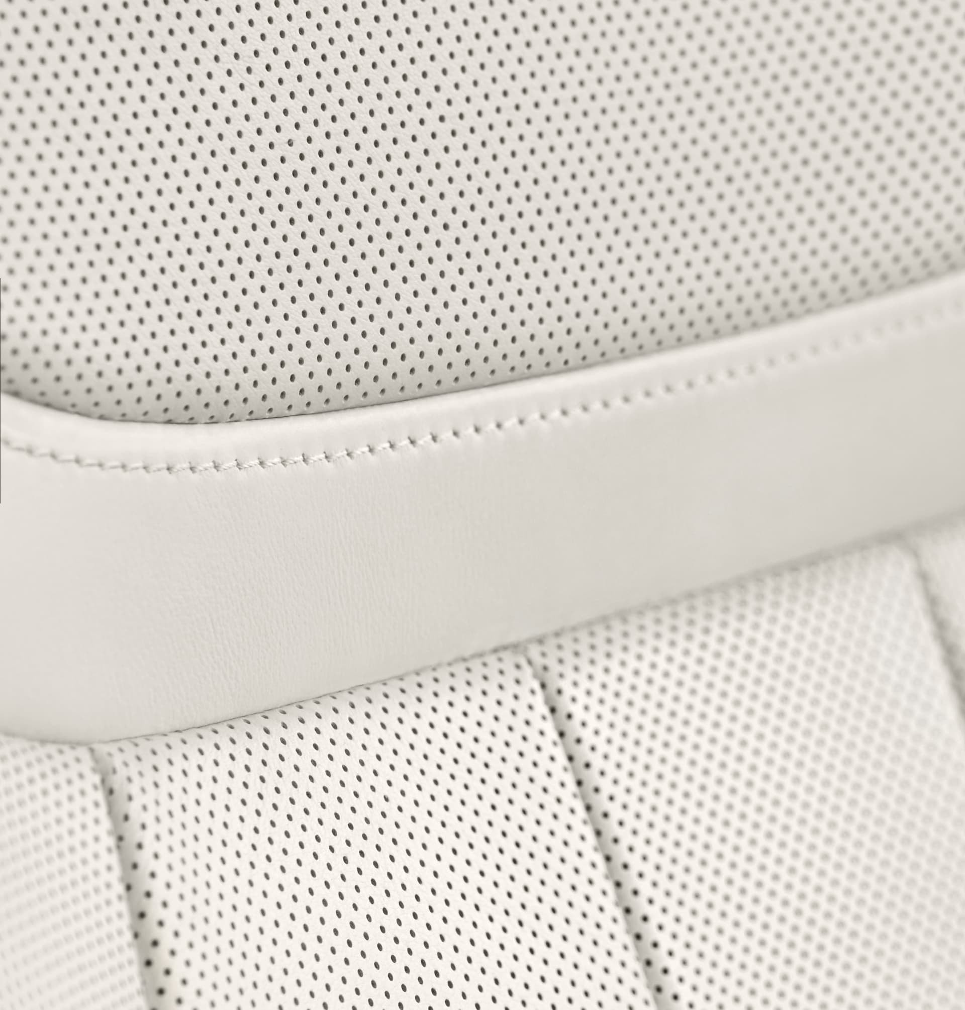 Primer plano del acabado y material del asiento de cuero perforado.