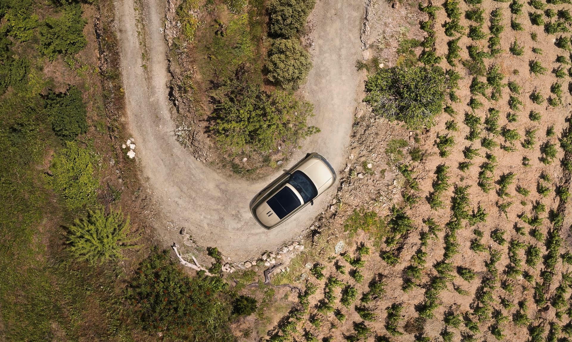 Toma aérea del Range Rover en un entorno natural, realzando su capacidad todo terreno.