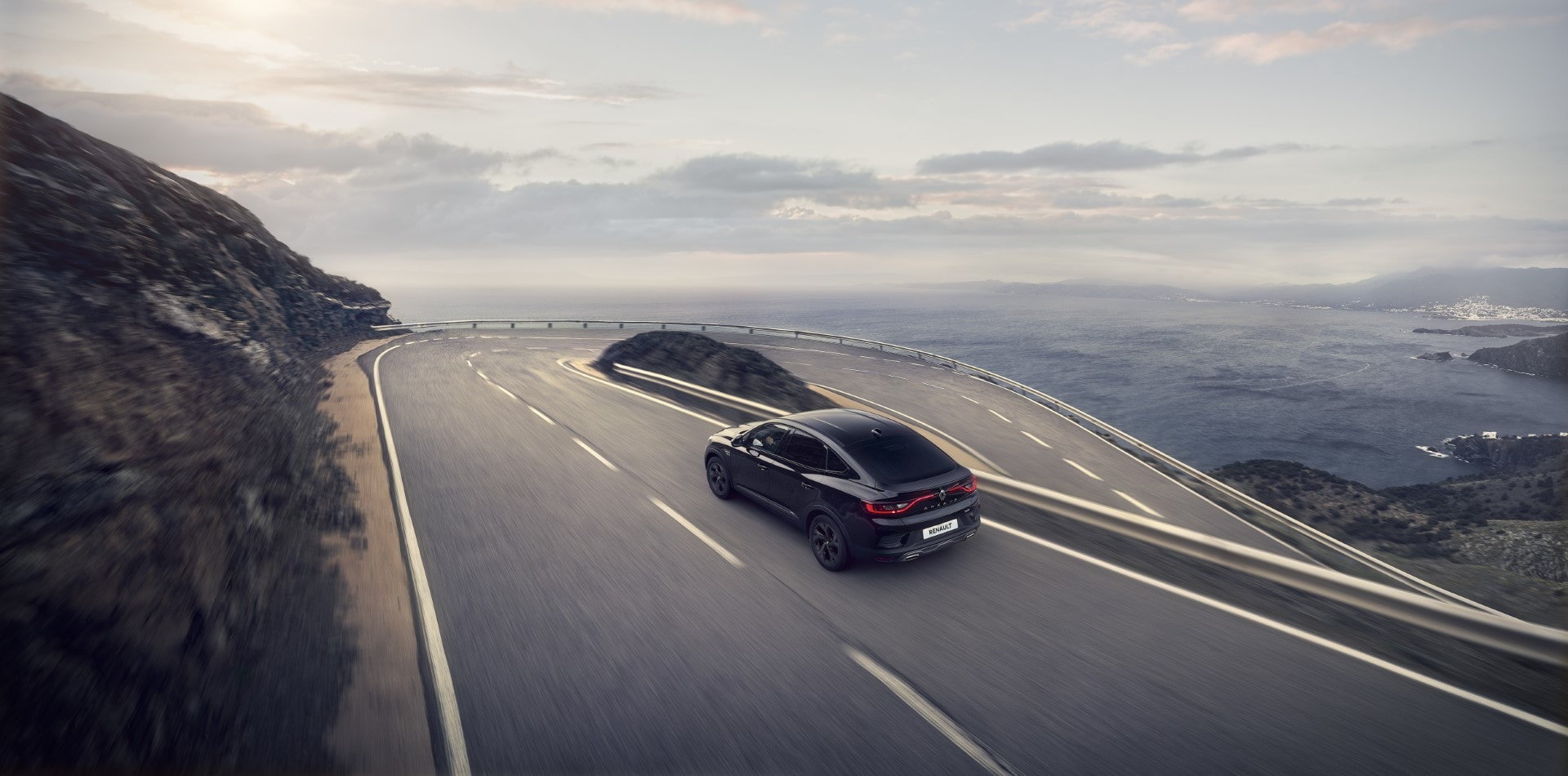 Captura dinámica del Arkana Híbrido en ruta, realzando su diseño aerodinámico.