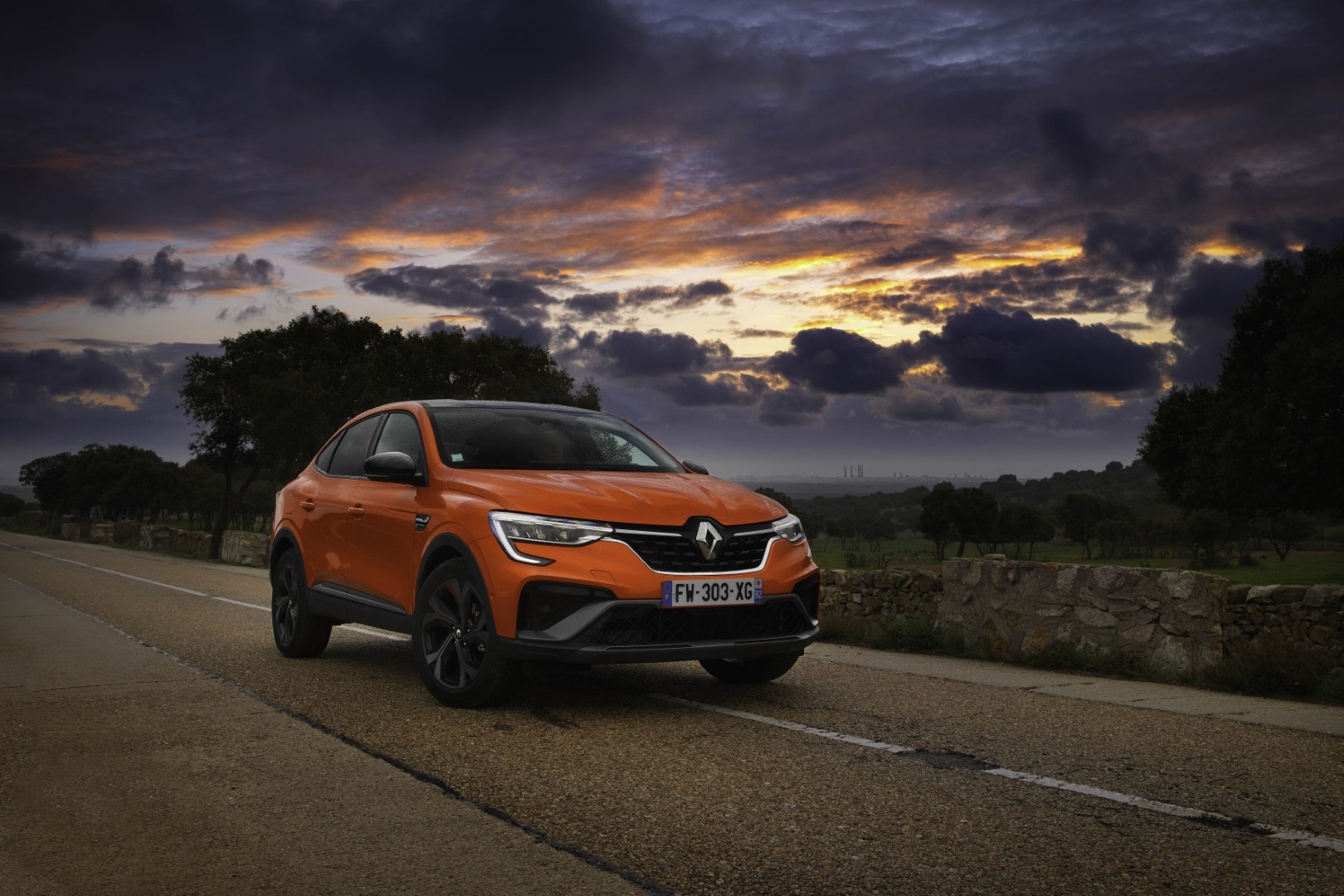 Imagen del Renault Arkana Híbrido en carretera durante el atardecer.