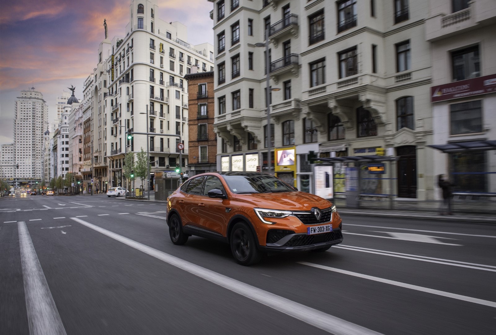 Renault Arkana Híbrido en movimiento, captado cruzando una intersección urbana.