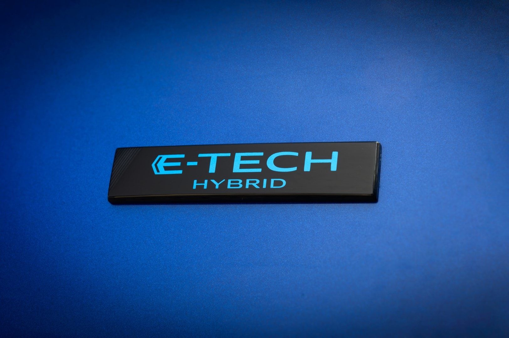 Detalle de la etiqueta E-TECH Hybrid, identificando la motorización híbrida del vehículo.