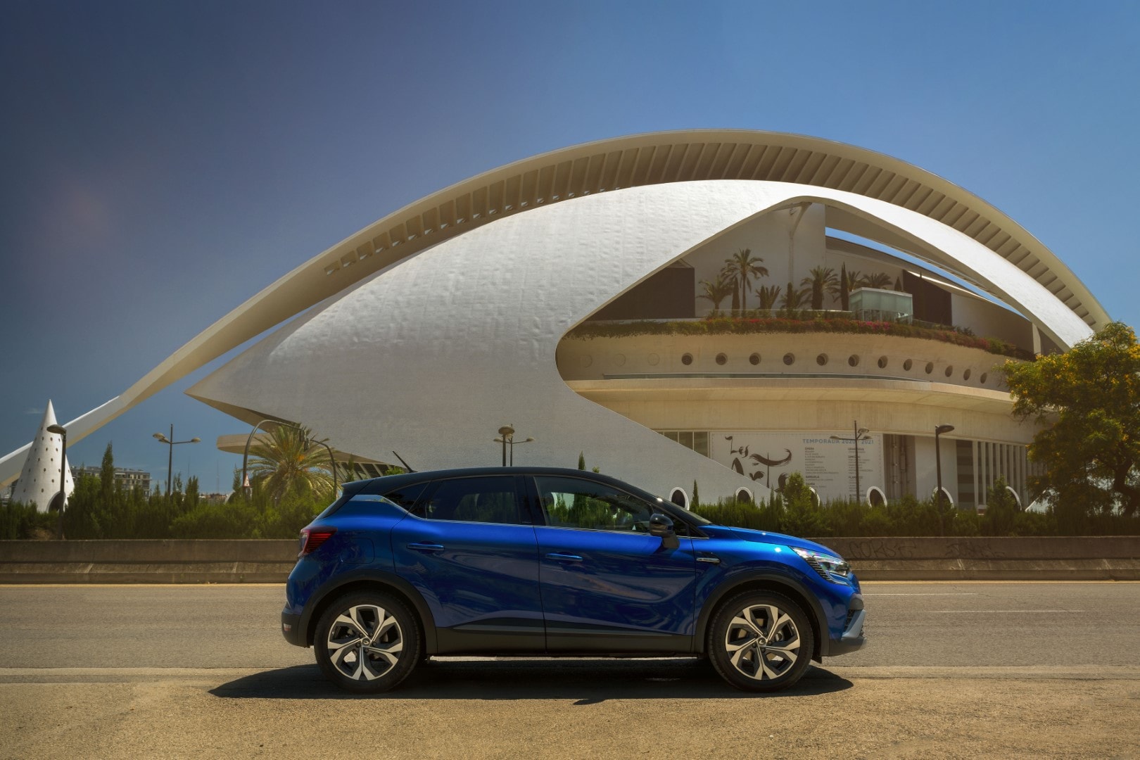 Imagen del Captur híbrido lateral con una impresionante estructura de arte de fondo