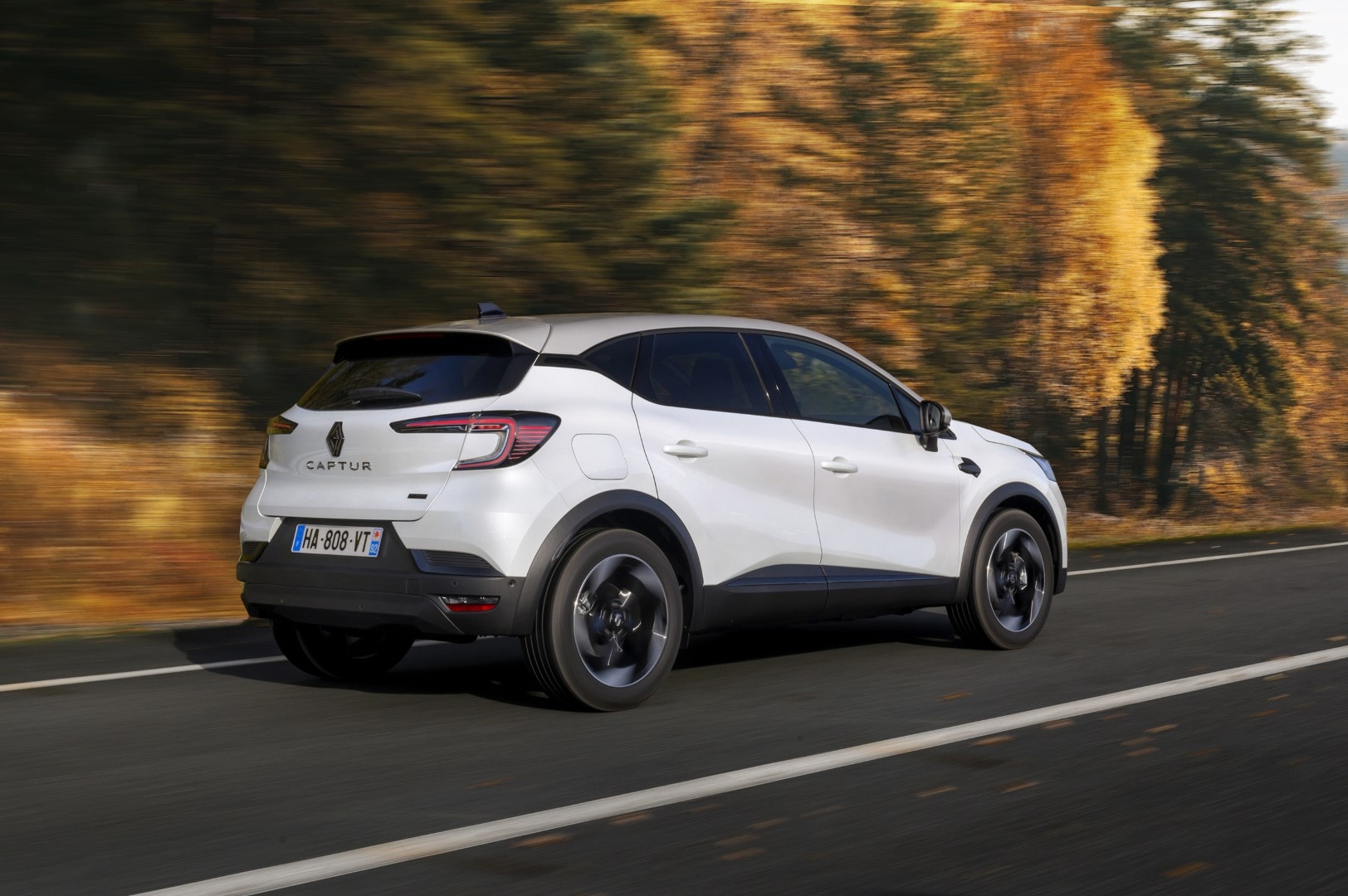 Lateral del Renault Captur en color blanco, integrado con paisaje natural de otoño.