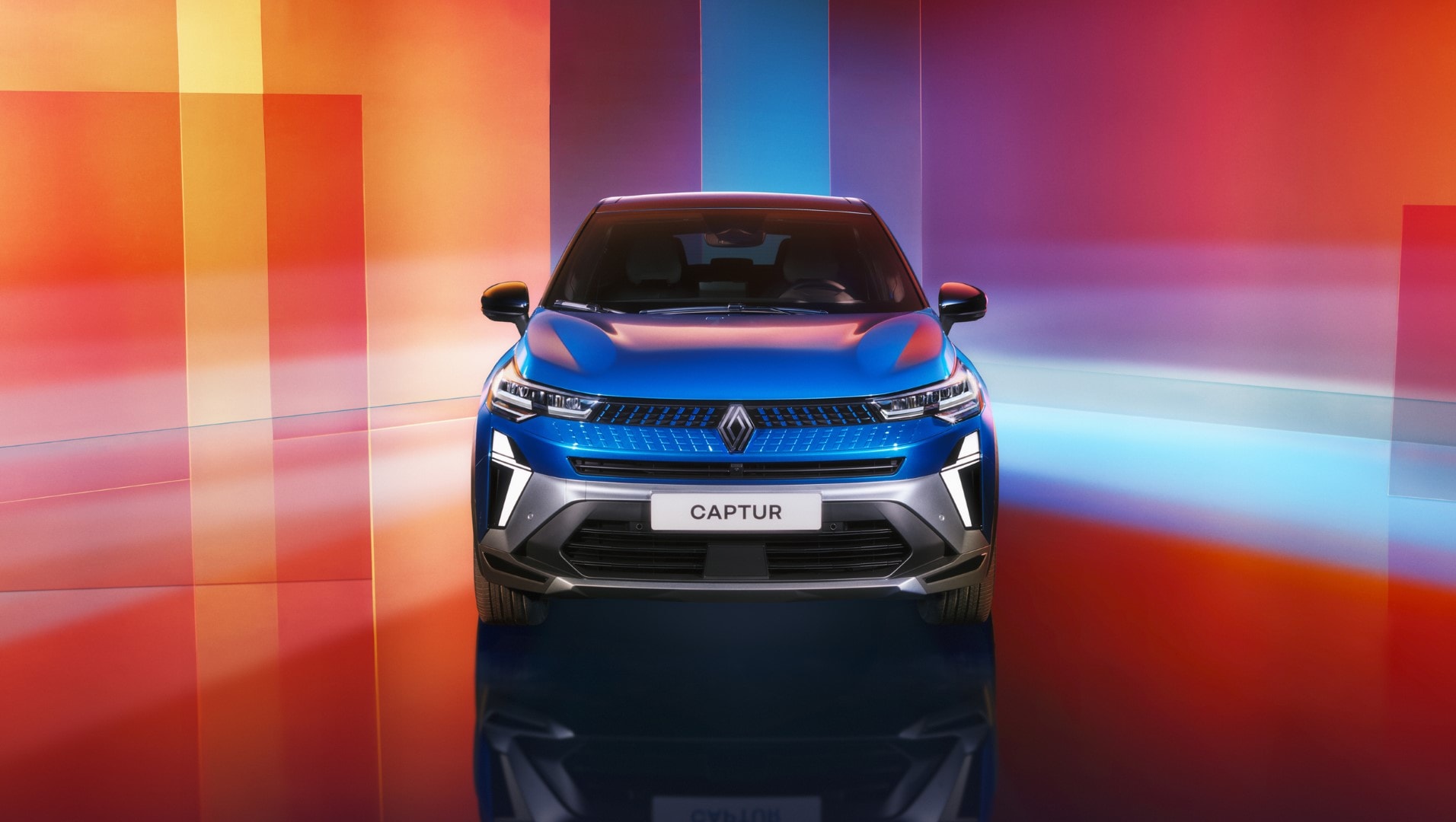 Frontal del Renault Captur con un fondo colorido que resalta su diseño.