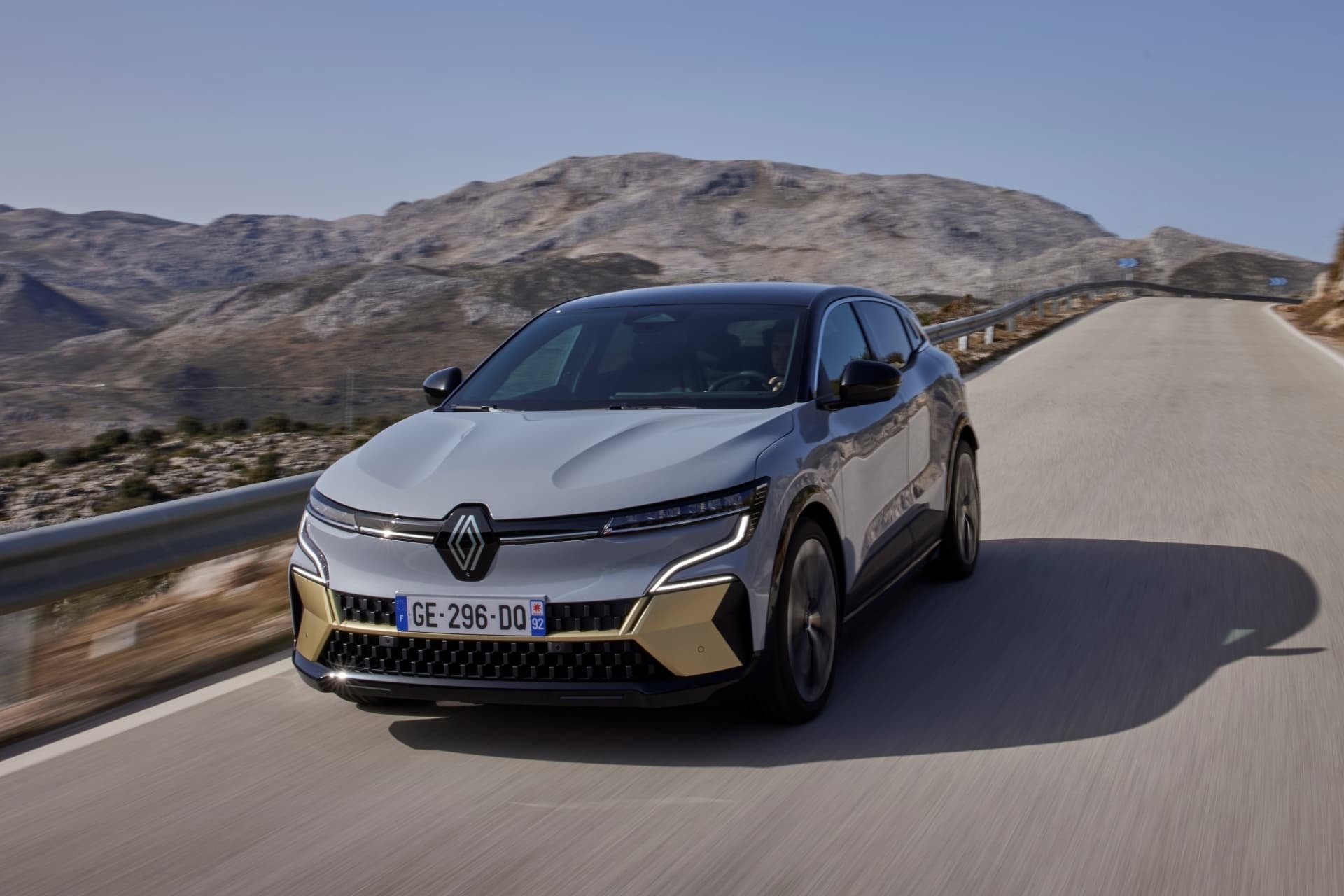 Renault Mégane E-Tech eléctrico en conducción dinámica, vista frontal y lateral.