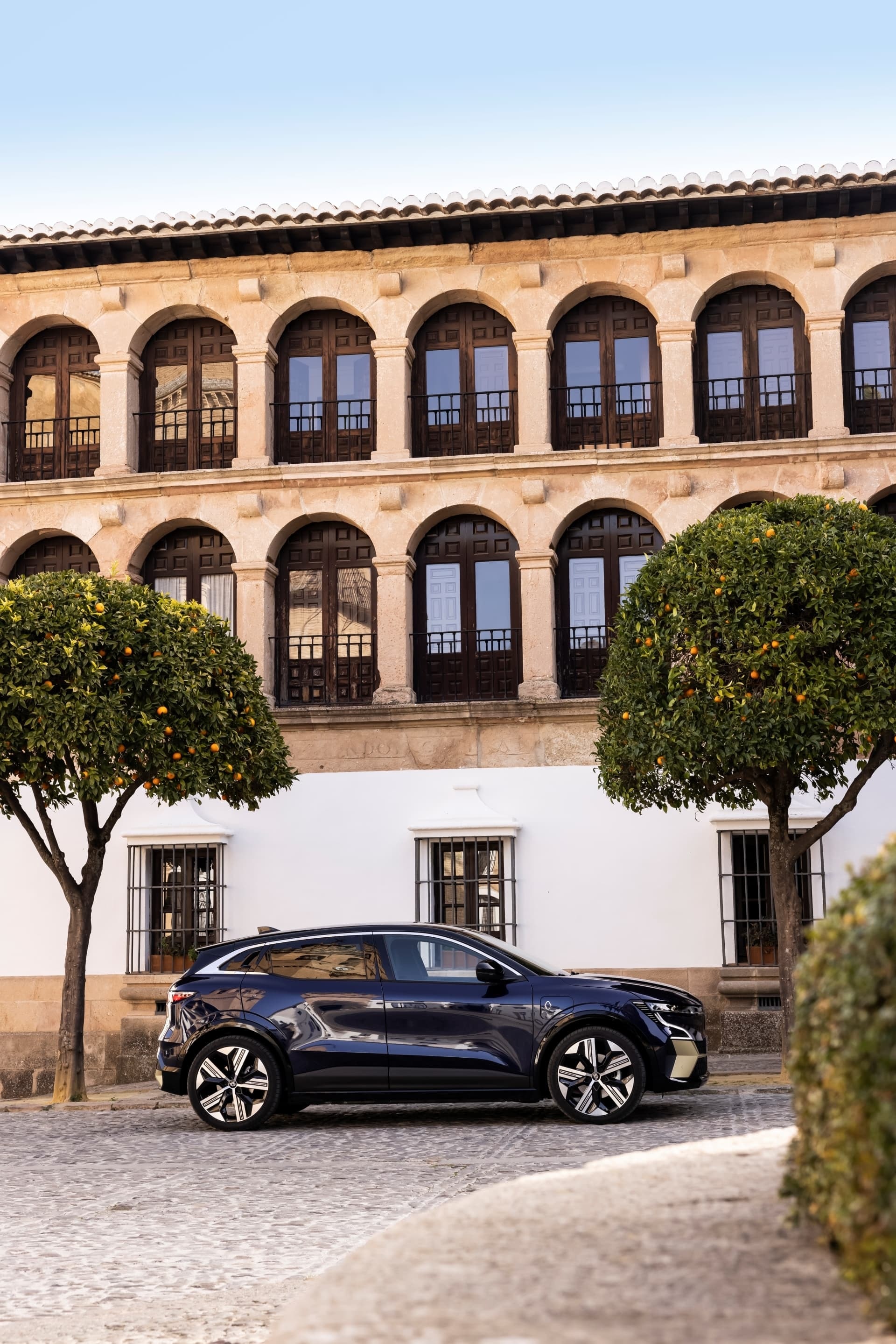 El Mégane E-Tech eléctrico estacionado, armonizando con arquitectura clásica.