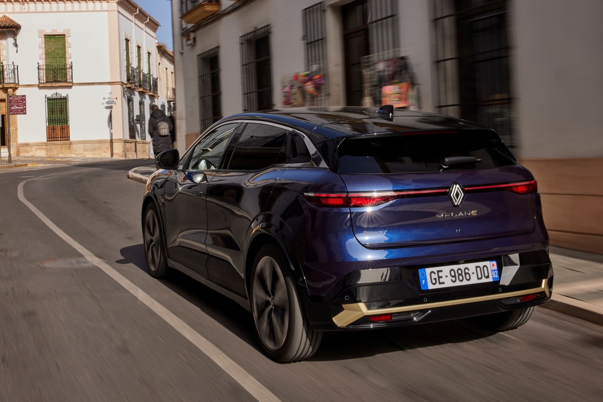 Imagen trasera en movimiento del Mégane E-Tech, demostrando su presencia en entornos urbanos.