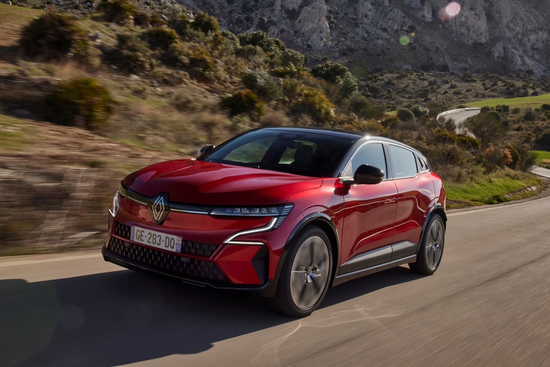 Conducción dinámica capturada en el Mégane E-Tech, lateral y frontal en foco.
