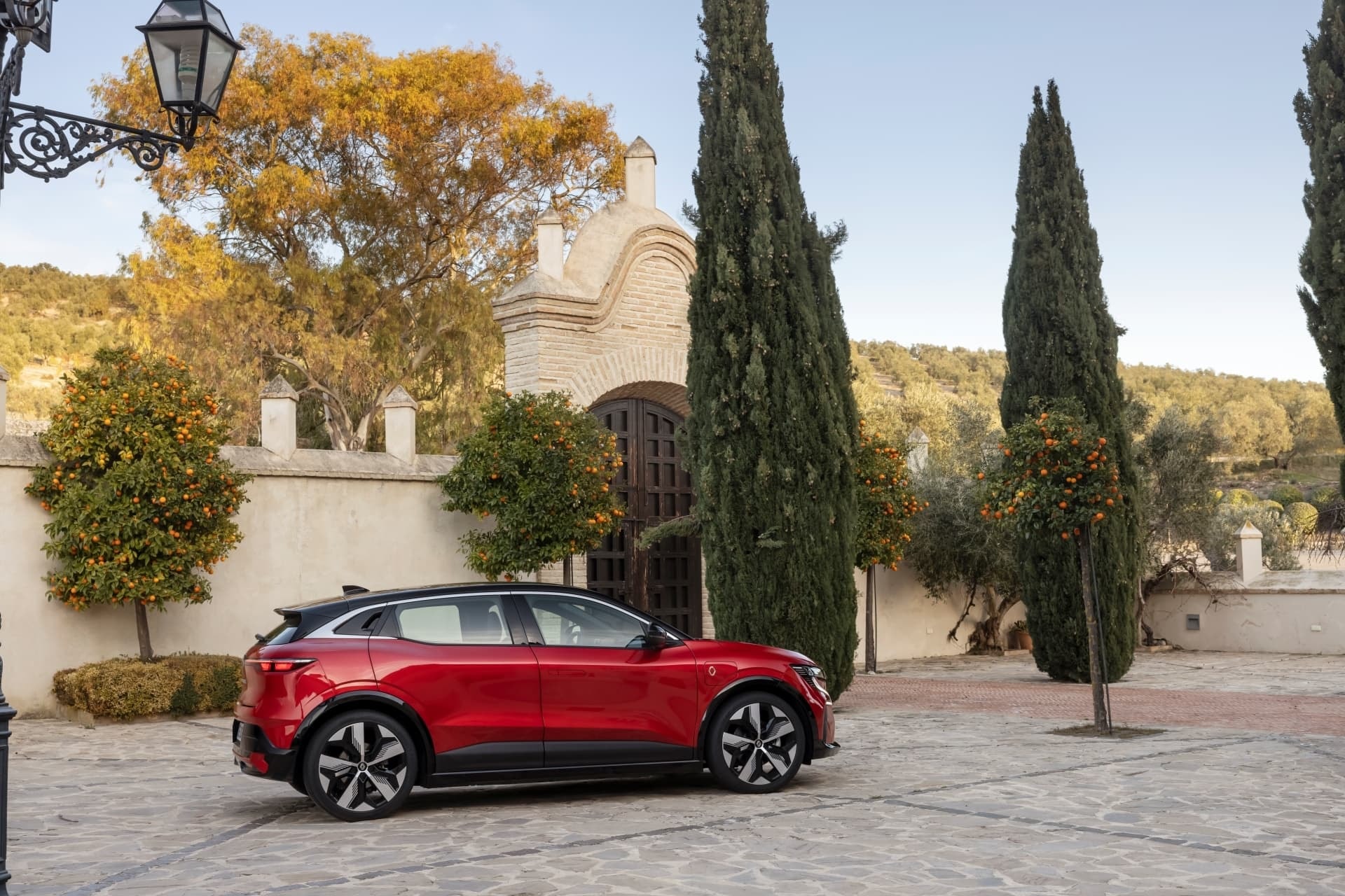 El costado del Mégane E-Tech resalta junto a la naturaleza en un entorno tranquilo.