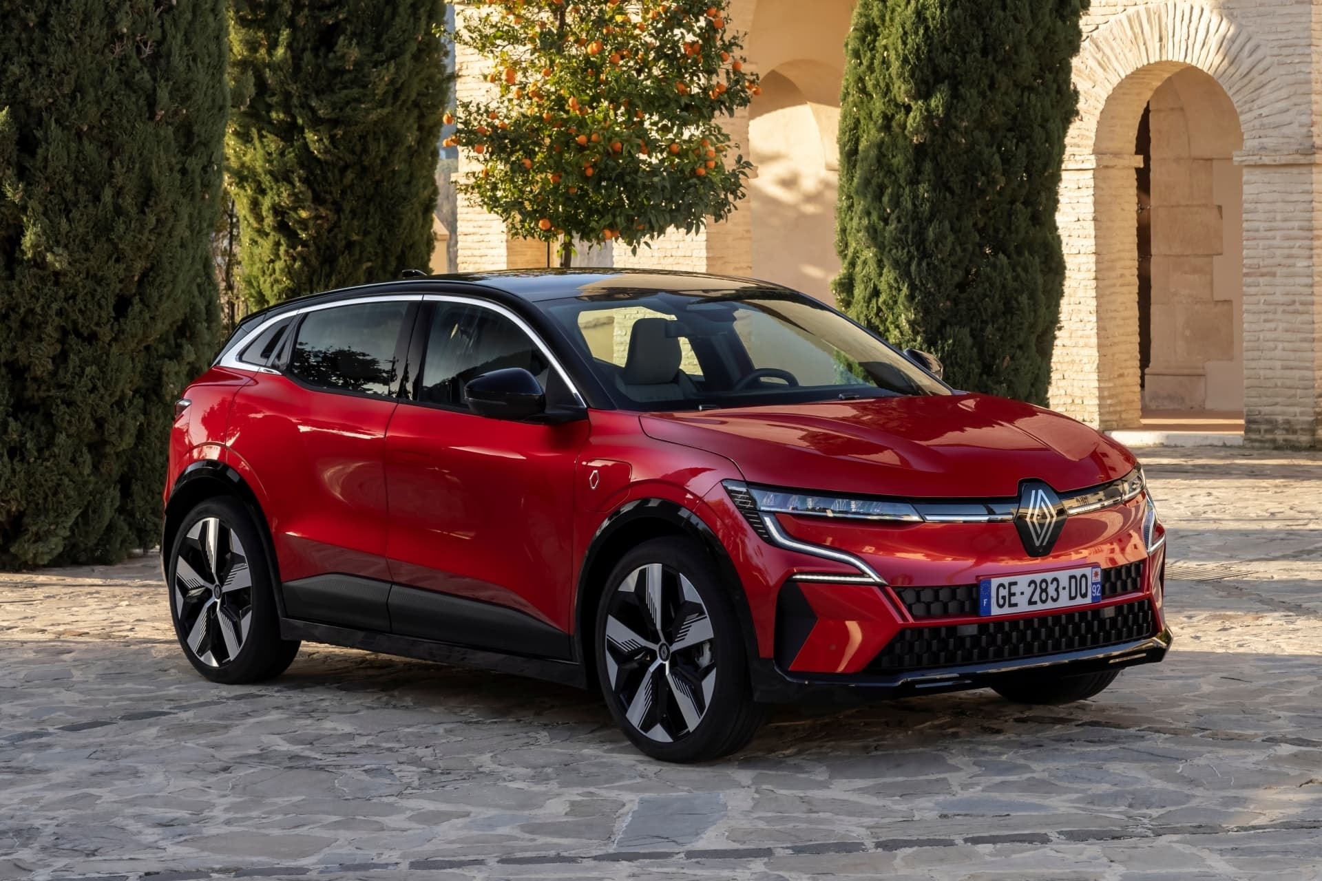 Vista frontal del Mégane E-Tech eléctrico ante un edificio histórico.